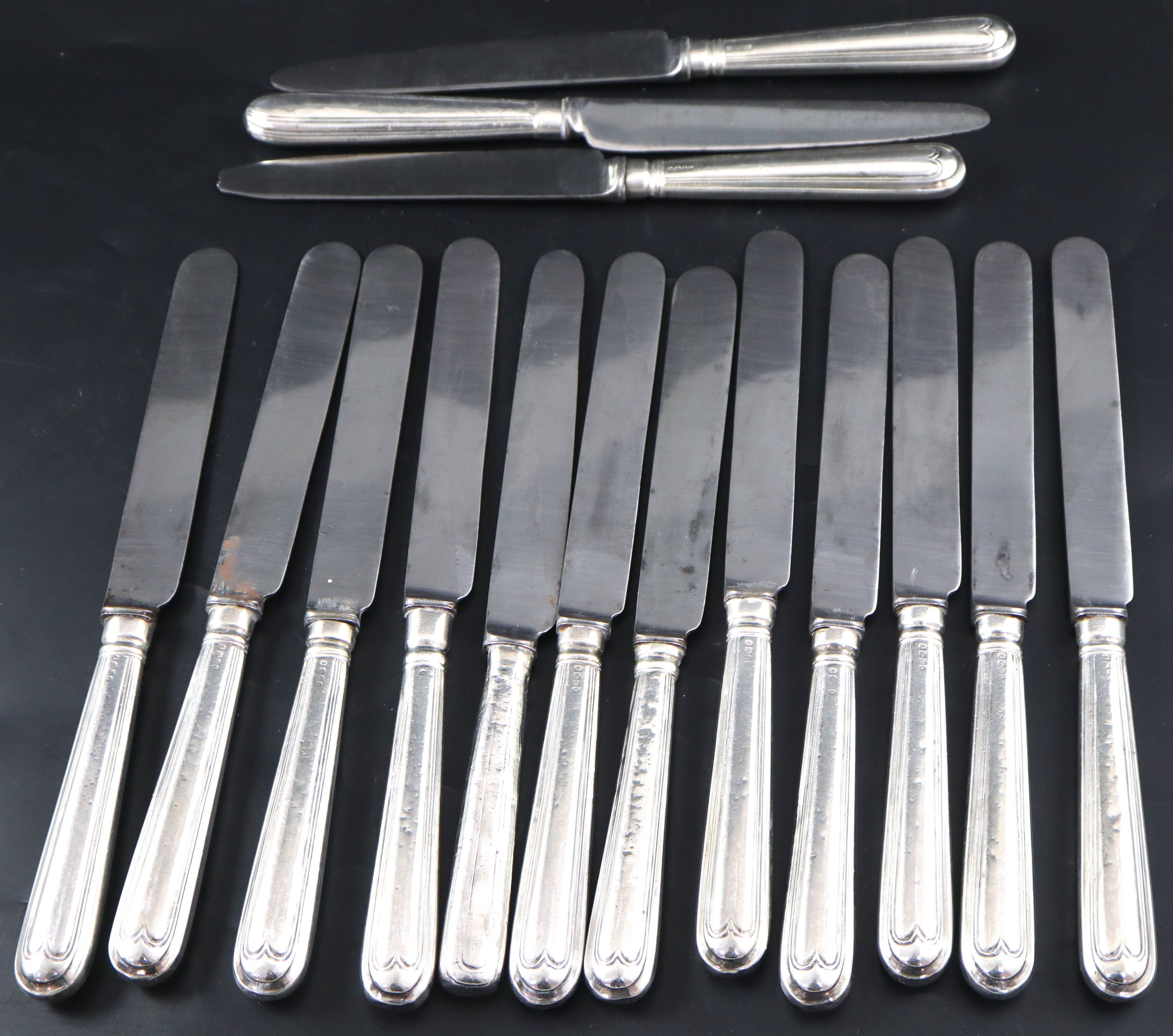 A harlequin set of fifteen mainly George IV silver handled table knives, approx. 27cm.